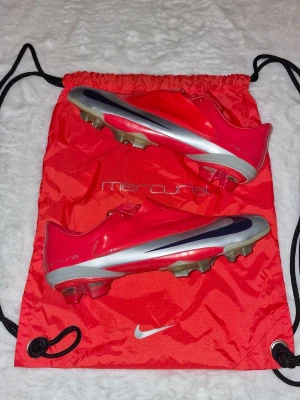 Nike Mercurial Vapor V FG - Nike Mercurial Vapor V FG I väldigt bra skick. Hel och fräsch   Inga defekter förutom två stycken på sista bilder. På sista bilden är det limmet som börjar lossna på både skorna, och Det går att limma om det om man vill.  Skick: 8/10 Storlek: 44 Produktkod: 354555-851  