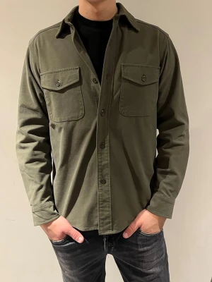 Uniqlo overshirt  - Säljer nu min snygga gröna uniqlo overshirt i storlek xs men som passar S. Modellen är 180cm. Hör av er vid fler frågor