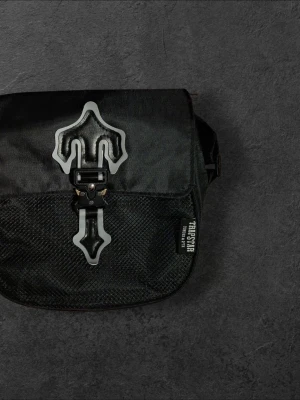 Snygg Trapstar Bag - Snygg svart bag från Trapstar i helt nytt skick. Perfekt för att göra klart din outfit. Vid frågor eller bud, var vänlig att kontakta mig.