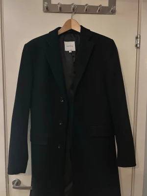 Svart rock från Studio Total - Stilren svart rock från studio total som är tillverkad i en ullmix. Rocken är storlek 46 och är använd endast någon enstaka gång