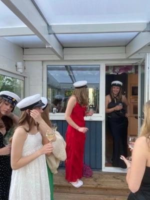 Superfin röd klänning med volanger  - Snygg röd långklänning med v-ringning och volangdetaljer. Klänningen har smala axelband och liknar en Rat&Boa-klänning. Perfekt för student eller sommarens festligheter. Använd en gång.