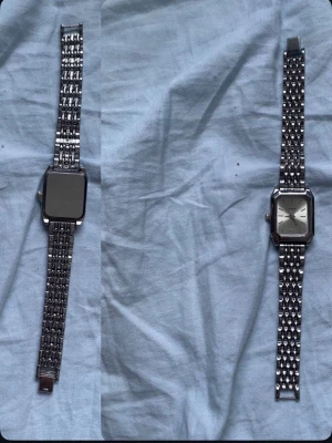 Silverfärgad fyrkantig klocka - Stilren klocka med fyrkantigt silverfärgat boett och matchande metallarmband. Klockan har en minimalistisk urtavla med tydliga markeringar och klassisk design. Perfekt accessoar för dig som gillar en clean och modern look.