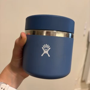 Hydro Flask 20 oz Food Jar - Blå Hydro Flask matburk med TempShield-isolering, 591 ml kapacitet. Utrustad med rostfritt stål och tättslutande lock. Inga synliga defekter, insidan är ren och utsidan har inget slitage. Perfekt för att hålla mat varm eller kall under dagen.