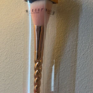 Makeupborste med roséguldskaft - Superfin sminkborste med mjuka, täta borst i ljusrosa och vitt. Handtaget är i roséguld och har en snyggt tvinnad design som påminner om en enhörningshorn. Perfekt för applicering av puder, bronzer eller rouge. Ny skick men man ser att den har legat i min låda… helt oanvänd