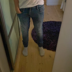 Blå slimfit jeans från Replay - Säljer ett par blå slimfit jeans från Replay med klassisk femficksdesign och snygga slitningar. Storleken på byxorna är 30/34. De är alltså rätt så långa med liten midja.Byxorna har börjat sitta tajt på mig och därför säljer jag dom. Perfekta för dig som gillar en smal siluett och stilren look. Pris kan diskuteras