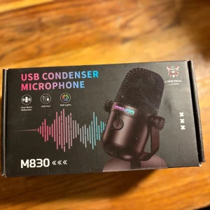 Onikuma M830 USB Condenser Microphone - Onikuma M830 är en USB-kondensatormikrofon med tydlig brusreducering, RGB-belysning och enkel USB-anslutning. Perfekt för streaming, gaming och inspelning. Produkten är i nyskick i originalförpackning.