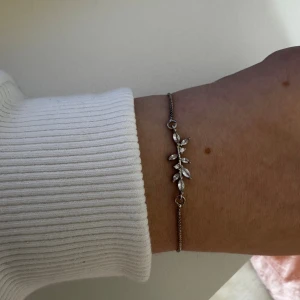 Silverarmband med glittriga stenar - Snyggt och tunt armband i silverfärg med justerbar låsning. Dekorerat med glittriga stenar i ett bladliknande mönster som ger en elegant vibe. Perfekt för dig som gillar stilrena detaljer och vill ha något som sticker ut lite extra.                              Vet inte vart den är ifrån och har aldrig använt. Skickar ditt köp inom 24h!💘