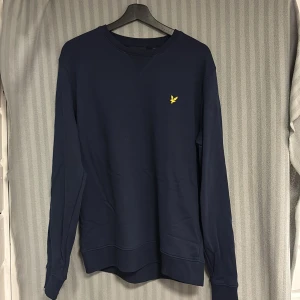 Mörkblå sweatshirt från Lyle & Scott - Mörkblå sweatshirt från Lyle & Scott. Jag är 180cm,67kg och den är öite för stor för mig skulle rekommendera den till någon som är lite längre och större.