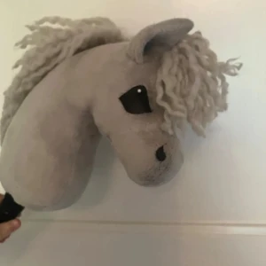 Söt käpphäst! - Söt fin grå käpphäst till salu!! Liten och lätt , grå med vit fluff man som håller. Gjord av @farastable på Instagram 2025. Bra skick. Man får med ett träns, pannband, grimma och ett par tyglar ( allt passar ) Vid intresse kontaktar du mig på @khs.daliahbacken  eller @lovisasponnys på instagram 😊 600 kr + frakt ink all utrustning den har. Pinne ingår om man vill hämta upp, finns i västra Blekinge 😁