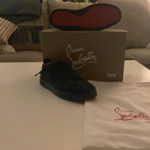 Svarta sneakers från Christian Louboutin - Snygga svarta sneakers från Christian Louboutin med den ikoniska röda sulan. 7/10 skick användet typ 7 gånger kan vara lite smutsig men går att göra rent med trasa
