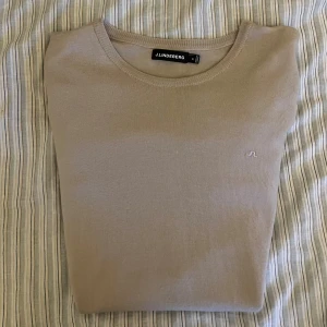 J-Lindeberg Merinoull tröja - Säljer denna snygga stickade  beigea/gråa tröjan från J.Lindeberg. Tröjan är i 100% merino ull och i storlek M, men bär något mindre mer som en S Har du några frågor? Tveka inte att höra av dig. Allt gott från Deluxe garderoben ⭐️