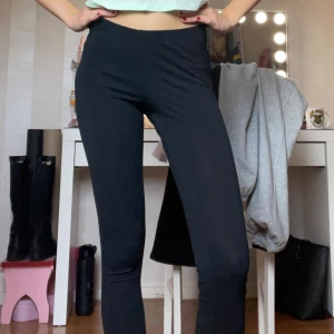 Svarta leggings - Svarta, tighta leggings med medel högmidja och stretchigt material. Perfekta för en chill vardagslook eller när du vill ha något bekvämt. Sitter snyggt och följer kroppen utan synliga detaljer eller fickor.