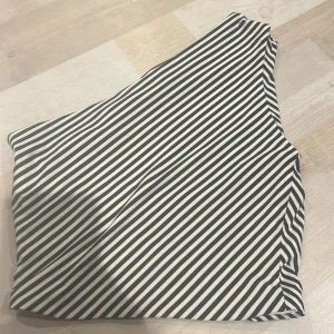 Randig svartvit topp - Säljer en snygg topp med svartvita diagonala ränder. Toppen har en enkel och stilren design som ger en cool och modern vibe. Perfekt för dig som gillar grafiska mönster och vill sticka ut lite extra. Materialet känns mjukt och följsamt mot huden. Varan är slutsåld överallt 