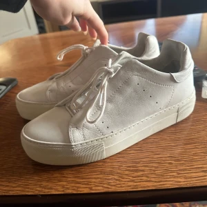 Vita sneakers med snörning - Snygga vita sneakers med snörning och en stilren design. Skorna är endast använd ett fåtal gånger så skicket är mycket bra.