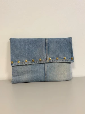 Datorfodral 💙 - Ljusblått datorfodral av återvunna jeans med filt och silke inuti, guldiga nitar och magnetisk knapp!💙 Fodralet är ca 37x27 cm🌟