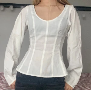 V- ringad blus - Säljer en superfin vit blus med vida ärmar och v-ringning. Den är lite korsettinspirerad och såå fin 💗Hör gärna av dig vid frågor