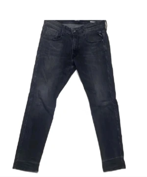 Replay - Säljer ett par klassiska blå jeans från Replay Anbass med fem fickor och tydliga kontrastsömmar. Byxorna har normal passform och raka ben. Perfekta till vardags för en avslappnad stil. 32 32