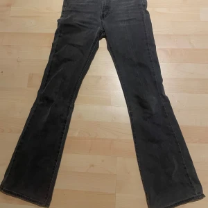 Svarta jeans från Levi's - Snygga svarta jeansbyxor från Levi's. Byxorna har en bootcut-stil som ger en retro känsla. Perfekta för en avslappnad look. 