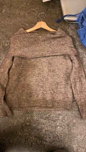 Brun offshoulder stickad tröja ONLY - Säljer en brun stickad tröja från ONLY i storlek XS. Tröjan har en bred offshoulder-krage som ger en chill och trendig vibe. Materialet är mjukt och stickat, perfekt för kyliga dagar. Långa ärmar och ribbade muddar för extra komfort.