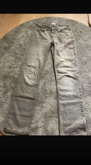 Grå raka jeans från Levi's - Säljer ett par grå jeans med raka ben. Jeansen har normal passform och är tillverkade i slitstarkt denim. Snygga detaljer med märke bak i midjan. Perfekt för dig som gillar enkel och stilren look.