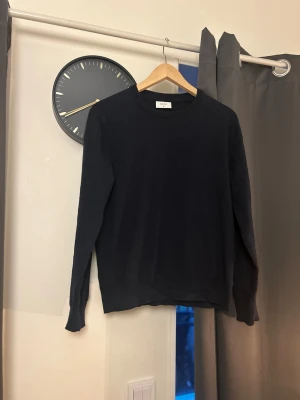 Mörkblå stickad tröja från Grunt XL - Snygg mörkblå stickad tröja från Grunt i storlek XL för barn. Tröjan har rund halsringning och långa ärmar, perfekt för dig som gillar enkel och clean stil. Materialet är mjukt och skönt, passar bra till jeans. Klassisk modell utan detaljer. Köpt för ca 600kr från en butik.