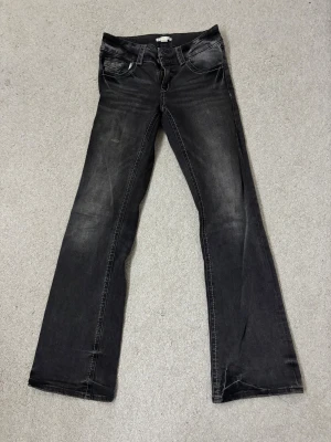 Svarta bootcut jeans från Gina Tricot - Snygga svarta jeans från Gina Tricot i storlek 164. Modellen har bootcut-ben och klassisk femficksdesign med kontrastsömmar. Jeansen är tillverkade i jeansmaterial och har låg midja. Perfekt för dig som gillar en cool och avslappnad stil.