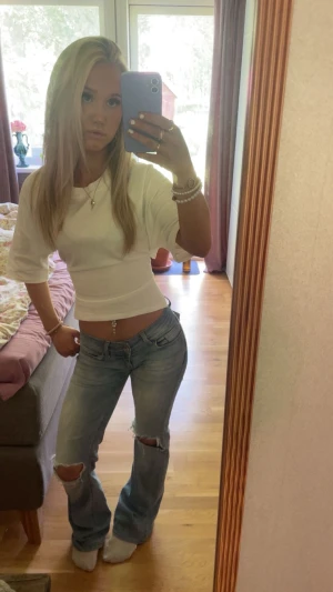 Topp med knytning från NELLY - Säljer denna fina vita topp från Nelly, inte alls mycke andvänd. Superfin.