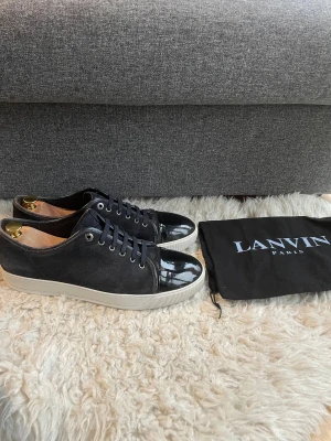Lanvin skor - Hej, säljer nu dessa Lanvin skor. Storlek 11 vilket motsvarar 45. Garanterad äkthet. Undersula i topp skick. Vid köp medföljer orginal dustbag. Otroligt fräscha. Mycket bra glans. Mindre defekt på tån, del av glanset borta (verkligen inget som påverkar användningen). Säljs dessvärre utan innersulor. Hör av dig vid eventuella frågor! /SR
