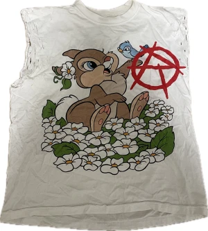 Reckless - Vit ärmlös t-shirt med stort tryck av kaninen från Bambi. Sidorna är disstressade för att se mer ”punk” aktig ut. 