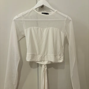 Vit topp nyskick  - Aldrig använd. Knytband som kan knytas både framtill och bak 