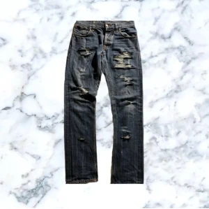 Nudie jeans slitna - Säljer ett par one of kind Nudie jeans för 799kr. Jeansen har snygga välgjorda slitningar och dom passar på dig som har W29 L32 och kom dm för bred och längd. Modellen är grim tim och dom sitter väldigt skönt! Kom dm för mer bilder och frågor om pris kan diskuteras vid snabb affär!