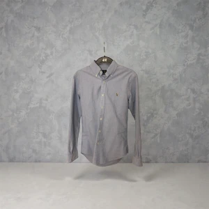 Ralph Lauren Oxford Skjorta - Superstilig och klassisk Oxford skjorta från Ralph Lauren i fin ljusblå färg. Storlek S och passform Slim. 