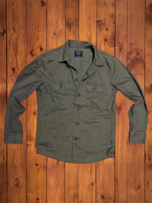 Vintage Abercrombie&Fitch Overshirt (sällsynt) - Säljer denna vintage sällsyna och asfeta overshirten från Abercrombie&Fitch. Riktigt fet och den är i väldigt bra skick och är riktigt snygg med en hoodie under. Storlek är XS och den passar som XS se måtten nedan. B=67cm A=50cm  