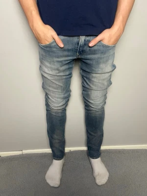 Replay Anbass ljusblå jeans - Säljer ett par Replay Anbass jeans i ljusblå tvätt med snyggt slitna detaljer. Mycket bra skick, inga hål. Skickar snabbt efter att du har gjort din beställning. Frågor? Skicka ett meddelande👍
