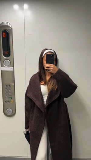 Mörkbrun teddyjacka med bälte - Säljer en lång, mörkbrun teddyjacka med bred krage och bälte i midjan. Bär storlek XXS men jackan har en oversized passform och är tillverkad i mjukt, fluffigt material. Aldrig frusit i den!