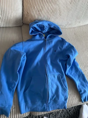 Ralph lauren  - En fin blå Ralph lauren zip hoodie i super bra skick! Den är i storlek xl barn så passar typ 14 åring.
