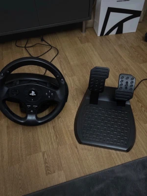 PlayStation Racing Wheel och Pedaler - Snyggt och välbevarat PlayStation ratt och pedalset för realistisk racingupplevelse. Kompatibel med PlayStation-konsoler, har alla nödvändiga knappar och funktioner. Inga synliga defekter eller slitage, redo att användas för spel. Perfekt för bilspel och simulering.