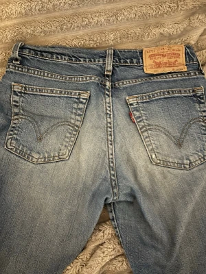Levi's 517 bootcut jeans blå - Säljer ett par low waist jeans med utsvängda ben från Levi's i ljusblå. De har fem fickor, Levi's patch bak och den röda Levi's-taggen på fickan. Jeansen är tillverkade i slitstarkt bomullsmaterial och har en snygg faded look.