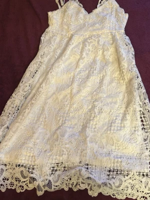 Vit spetsklänning med smala axelband - Vit klänning med spets, nästan oanvänd och väldigt bra skick