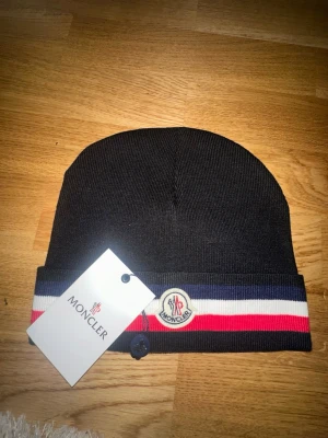Svart randig mössa  - Helt oanvänd. Inga tecken på användning. Topp kvalité och priser kan även diskuteras. Köp innan det tar slut!!