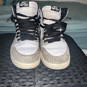  Air Jordan 1 Retro High OG White Cement - sparsamt använda, luktfria och i så fint skick att du knappt märker att de ens varit på fötterna.  Det här är inte bara sneakers det är ett statement. Den där unika touchen som ungdomar älskar, något som inte alla andra springer runt med. Perfekt för dig som vill sticka ut lite extra utan att ens försöka. Priset går självklart att diskutera!!!  (Skokartong följer med)