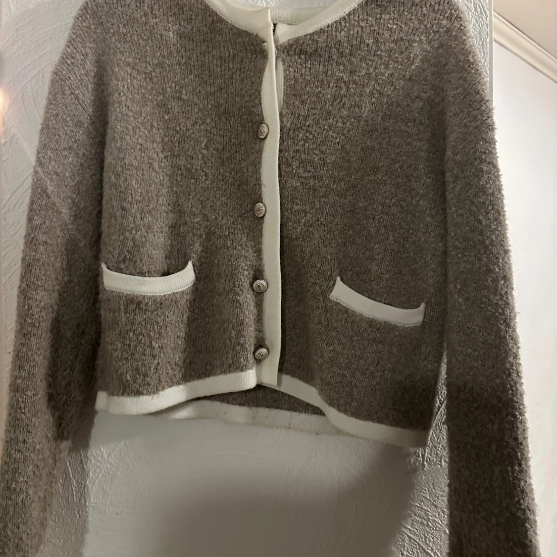 Beige stickad kofta med vita detaljer