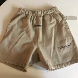 Helt nya shorts från Fear of God Essentials - Helt nya  shorts från Fear of God Essentials med elastisk midja och en bakficka. Mjukt bomullsmaterial och logga framtill samt en liten patch med 'ESSENTIALS' vid midjan. Perfekta för chill dagar och streetwear vibes. Pris kan diskuteras😊