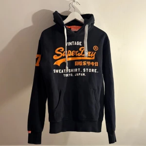 Superdry hoodie - Säljer en sjukt snygg superdry hoodie som är väldigt eftertraktad, skynda dig innan den blir såld finns ej många såna här ute för dethär priset o kvaliten så skynda!