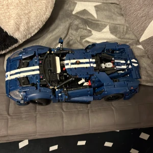 LEGO Technic Ford GT - Snygg LEGO Technic Ford GT i blått med vita racingränder. Modellen är komplett och i mycket fint skick, inga synliga skador eller saknade delar. Perfekt för bilentusiaster och LEGO-samlare som vill ha en detaljerad och funktionell byggmodell.