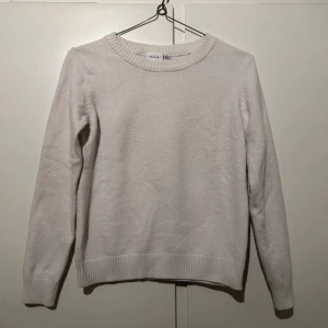 Vit stickad tröja från Vila - Enkel och stilren vit stickad tröja från Vila med rund halsringning och ribbade muddar vid ärmslut och nederkant. Perfekt basplagg med normal passform och lång ärm, passar till allt och är supermjuk.