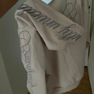 Dusty pink oversized hoodie med old English tryck - •Dusty pink, hoodie med dragkedja  •Textdetaljer i old English typsnitt på ärmarna och huvan.  •Hoodien har en oversized passform och en stor krage.                                                             storlek M Inga defekter.                                                                                     (Läs alltid min profil för villkor)