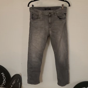 Grå jeans Replay Thad 14A - Säljer ett par grå jeans från Replay, modell Thad. Jeansen har klassisk femficksdesign, raka ben och snyggt tvättad finish. Passar dig som gillar en stilren look med lite edge. Perfekta till sneakers och hoodie.