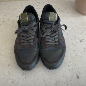 Valentino Rockrunner sneakers i mörka toner - Säljer ett par Valentino rockrunners! Skick 7/10. Storlek 43. Perfekta i höst/vinter. Hör av er vid funderingar