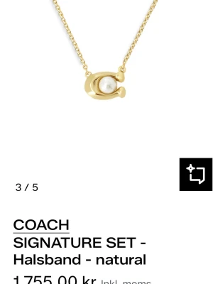 Coach halsband  - Stilrent halsband från Coach i guldton med ett C-format hänge och en vit pärldetalj i mitten. Kedjan är tunn och elegant, perfekt för att lyfta vilken outfit som helst. Ikonisk design med lyxig känsla och diskret logga.